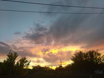 Low angle view of silhouette trees against sky