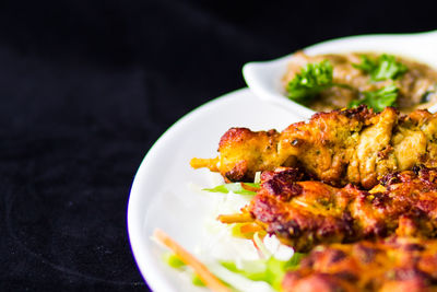 Close-up of food in plate against black background