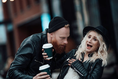 Young couple holding ice cream in city