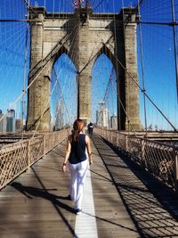 Rear view of woman walking on brooklyn bridge