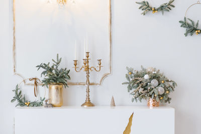 Christmas decor in a classic living room or bedroom in bright colors. spruce branches in gold vases