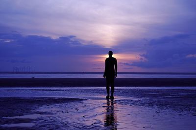 Rear view of a man standing on beach