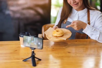 Woman holding drink served on table in restaurant