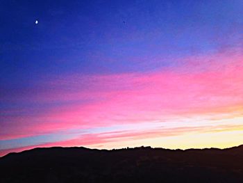 Silhouette landscape against sky at sunset