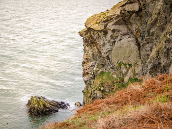 Rock formations by sea against sky