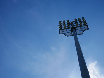 Low angle view of floodlight against blue sky