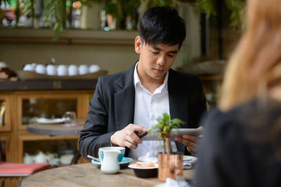 Young man using laptop in restaurant