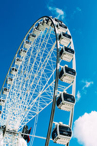 Low angle view of ferris wheel against blue sky