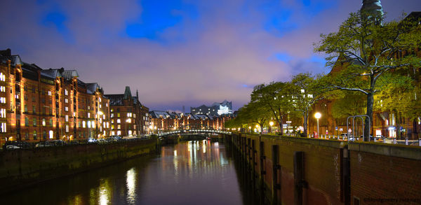 Bridge over canal in city at night