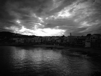 River in city against cloudy sky