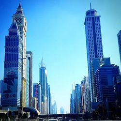 Low angle view of skyscrapers against blue sky