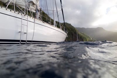 Close-up of boat sailing on sea against sky