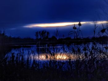 Scenic view of lake against sky at night