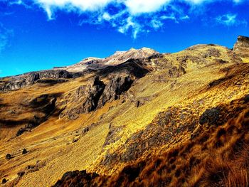 Scenic view of mountains against blue sky