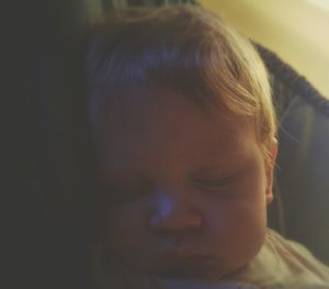 Close-up of cute baby sleeping on bed