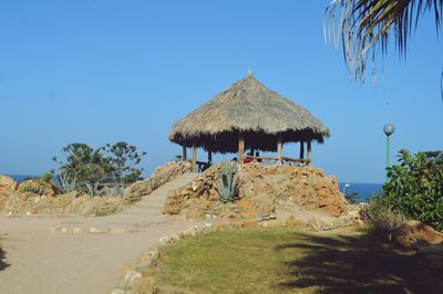 Traditional windmill on landscape against clear sky