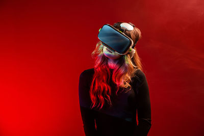 Woman standing against red background