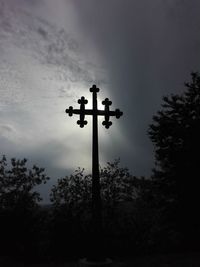 Low angle view of silhouette cross against sky at dusk