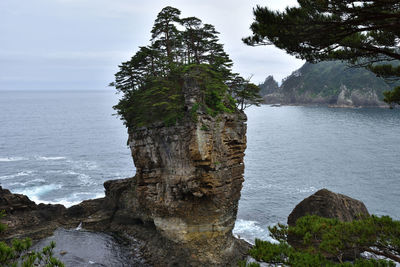 Rock formation by sea against sky