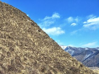 Scenic view of mountains against blue sky