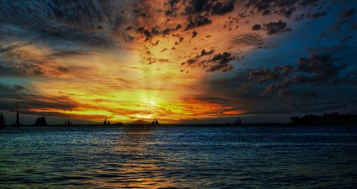 Scenic view of sea against dramatic sky during sunset