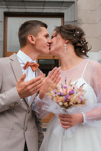 Groom hug and kiss bride in palm grove. wedding day for two. lovely weeding couple. young lovers.