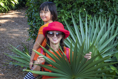 Portrait of smiling mother with daughter amidst plants