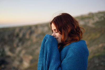 Portrait of beautiful woman on land against sky during sunset