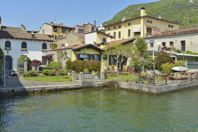 Buildings by lake against clear sky