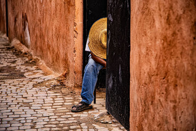 Man standing on footpath by street