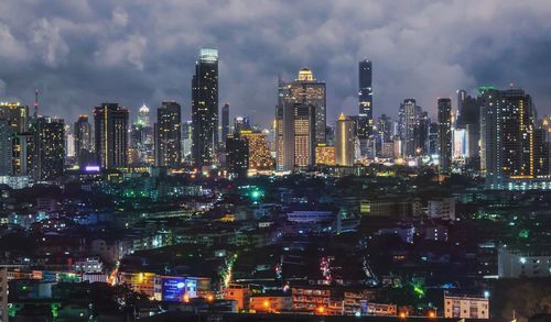 Illuminated cityscape against sky at night