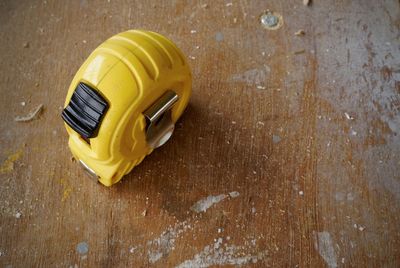 High angle view of yellow carpentry measure tape on wooden table