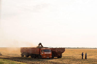 People on agricultural field against sky