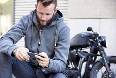 Man using mobile phone while sitting in bus