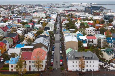 High angle view of houses by sea against sky