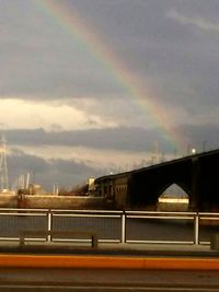 Blurred motion of highway against rainbow in sky