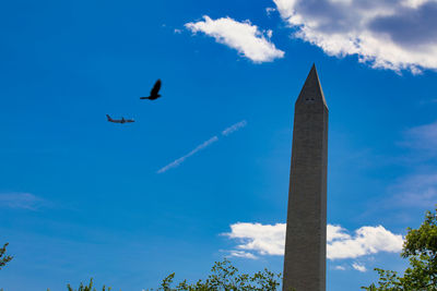 Low angle view of airplane flying against blue sky