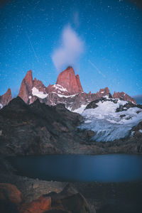 Scenic view of snowcapped mountains against sky at night