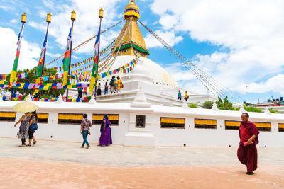 People walking in temple against sky