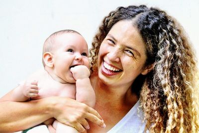 Portrait of happy mother carrying cute daughter