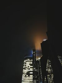 Illuminated cityscape against sky at night