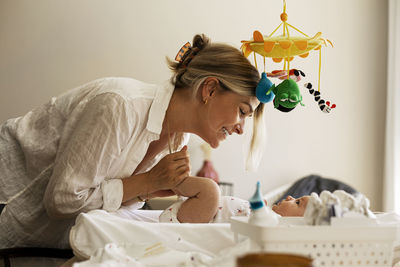 Side view of happy woman spending leisure time with son at home