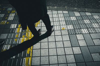 Low section of person standing on tiled floor