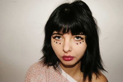 Close-up portrait of woman with make-up over white background