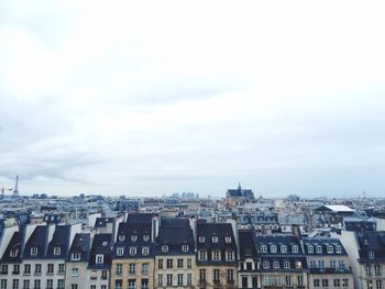 Scenic view of residential district against cloudy sky