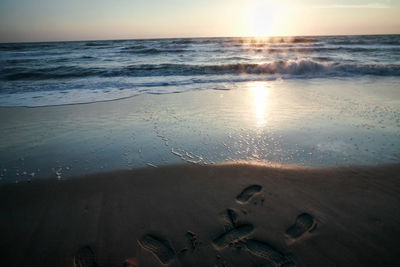 Scenic view of beach against sky during sunset