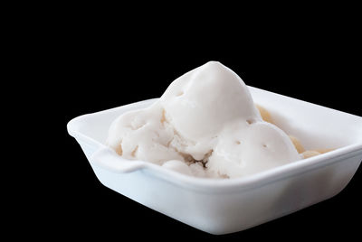 Close-up of ice cream in bowl over black background