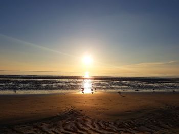 Scenic view of beach against sky during sunset