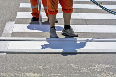 Low section of man standing on road