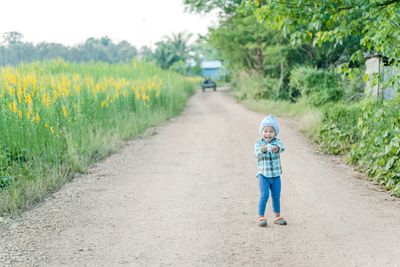 Portrait of happy boy standing on country road